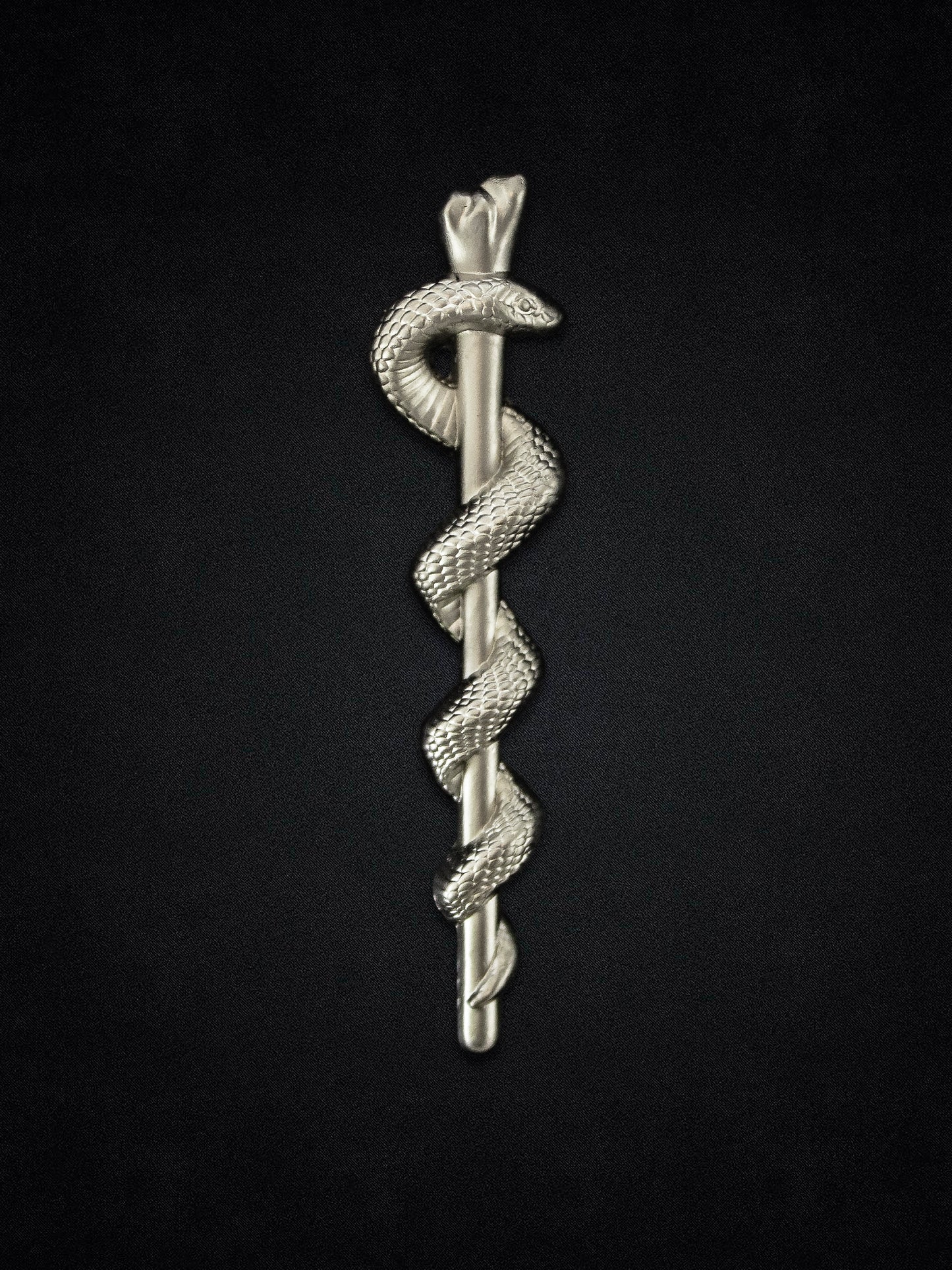 Silver Rod of Asclepius with snakes on a black background